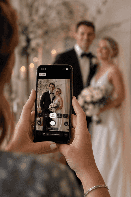 Wedding couple being photographed with a smartphone